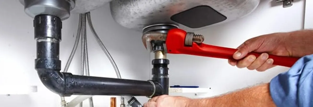 Garbage disposal repair technician tightening the sink drain and disposal connection in El Paso, TX